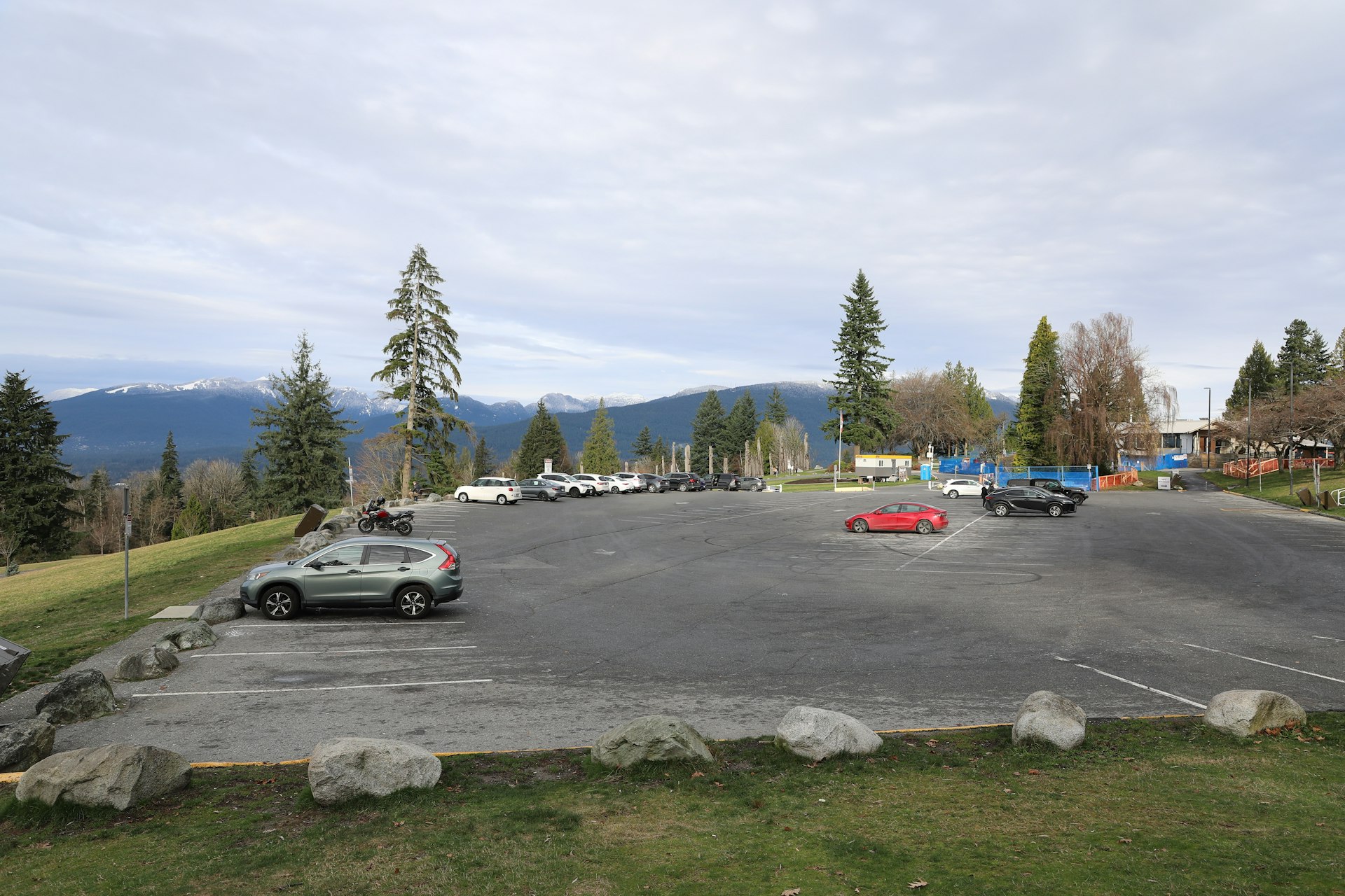 Cars parked in a lot with mountains in background.